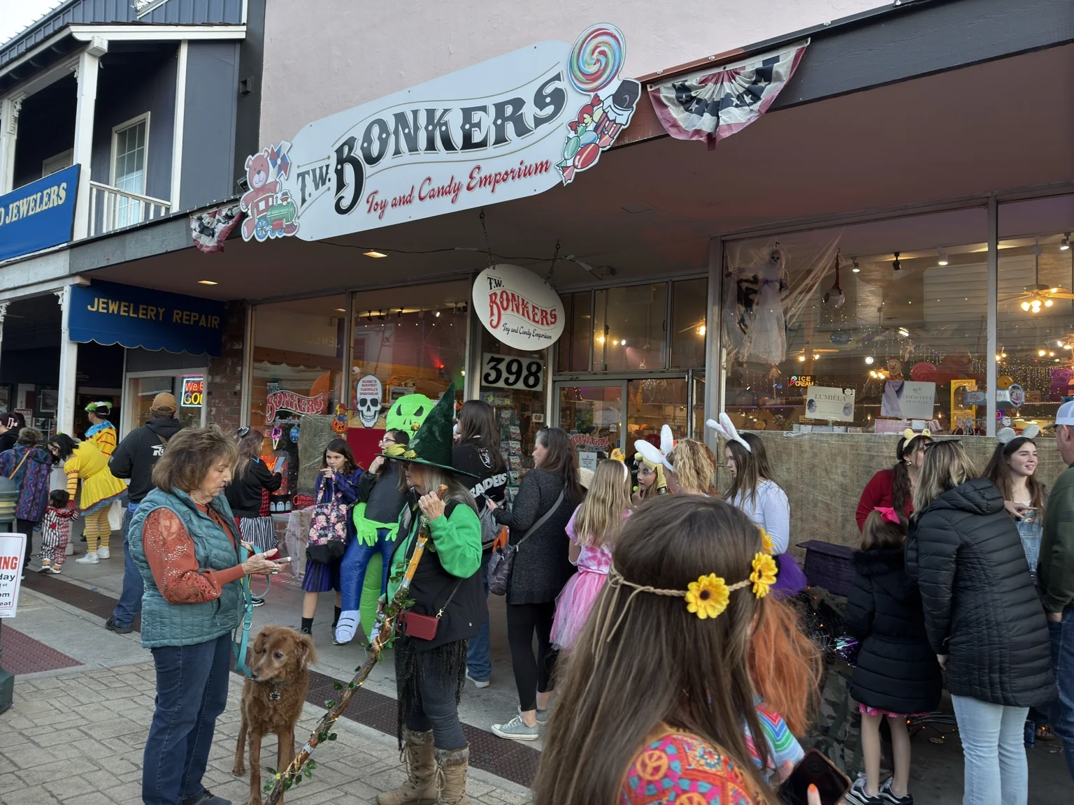 Families in costume gathered outside T.W. BONKERS during Trick or Treat on Main